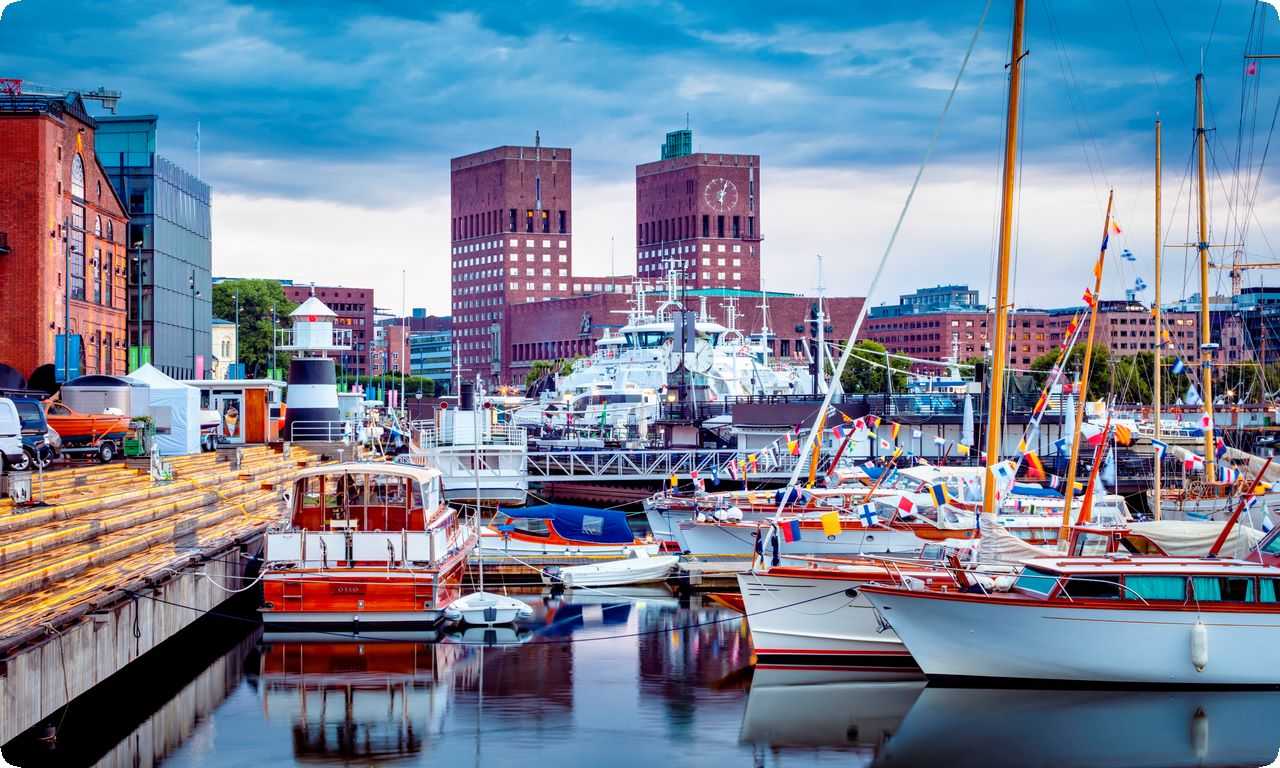 Красивая набережная в Осло с красивыми домами и лодками на фоне